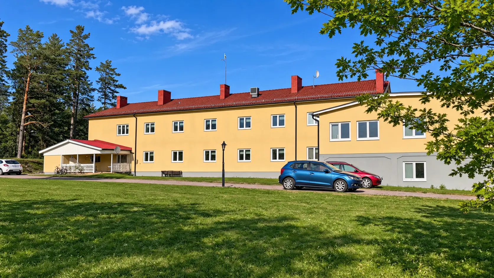 Fastigheten på Norra Storgatan 10A–B med uppfart, gräsmatta och vit entrédel